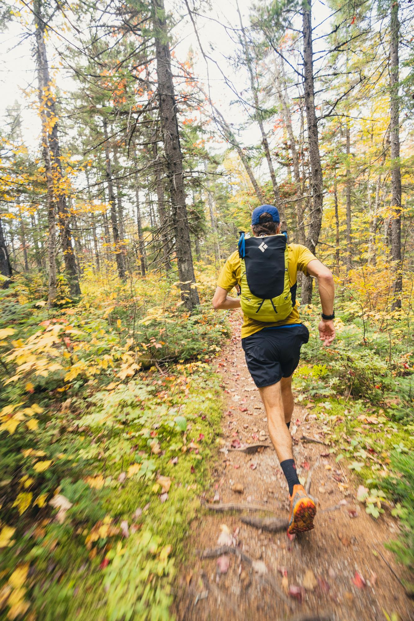 A person running outside with a Black Diamond backpack