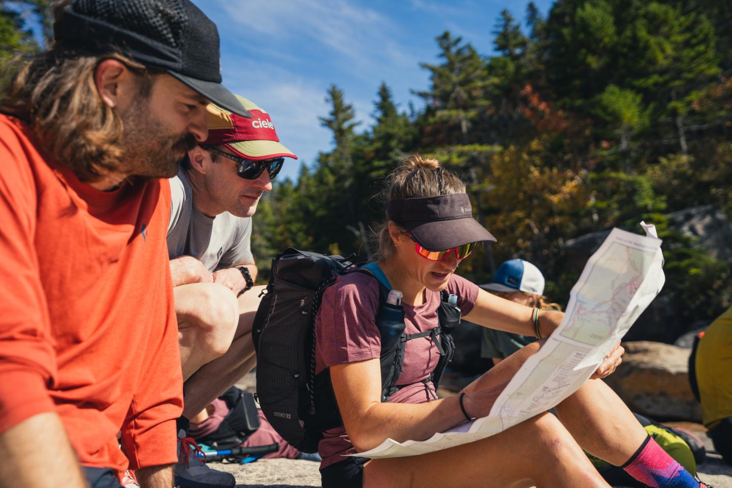 Three people reading a map outside